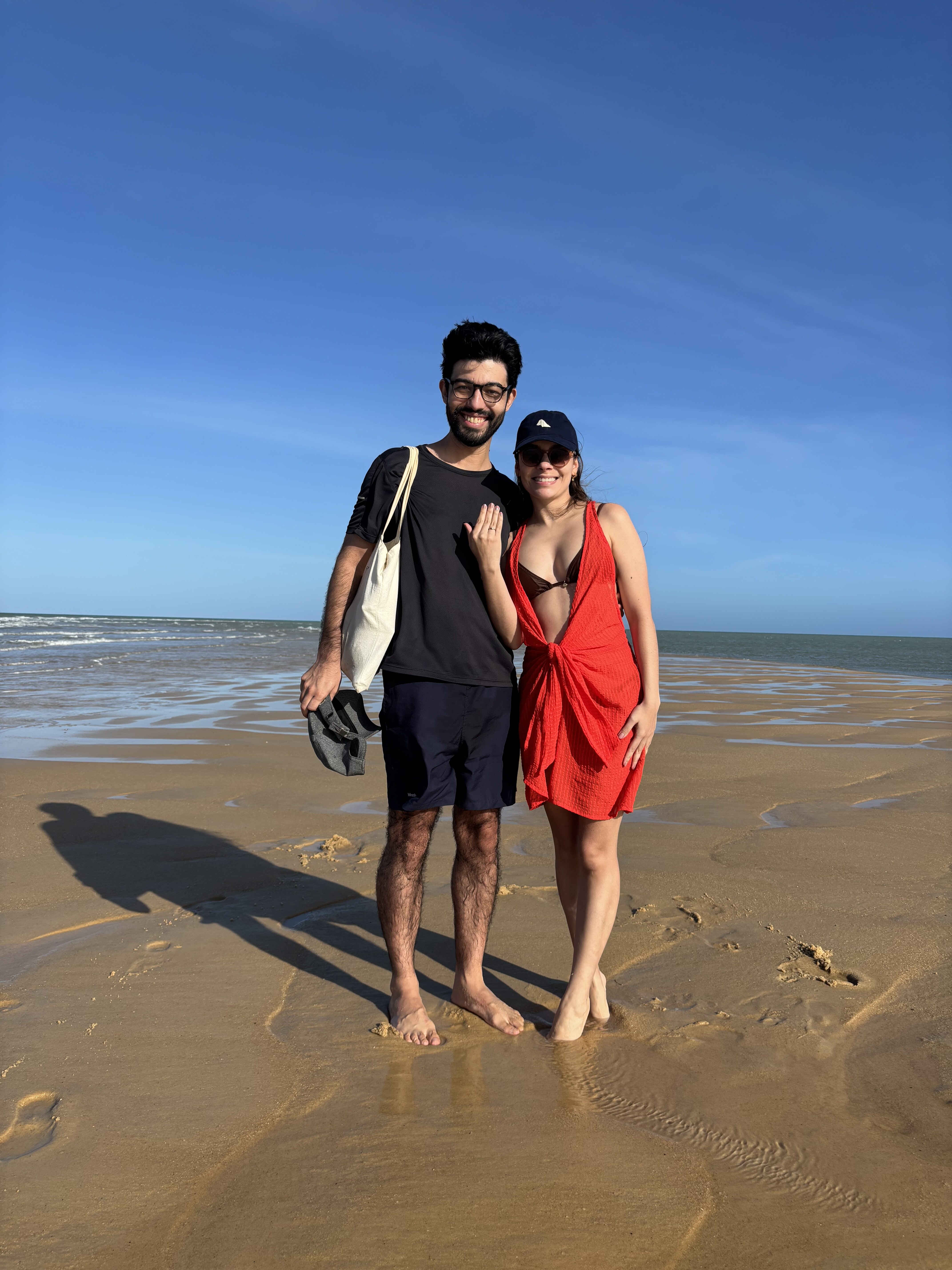 Natália e Renato celebrando o noivado na praia